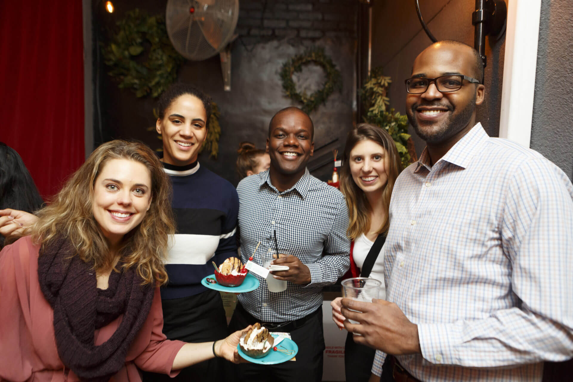 Five individuals at Ollie social event with drinks and ice cream